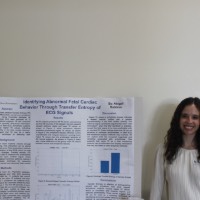 A student standing next to a cardiac behavior project.